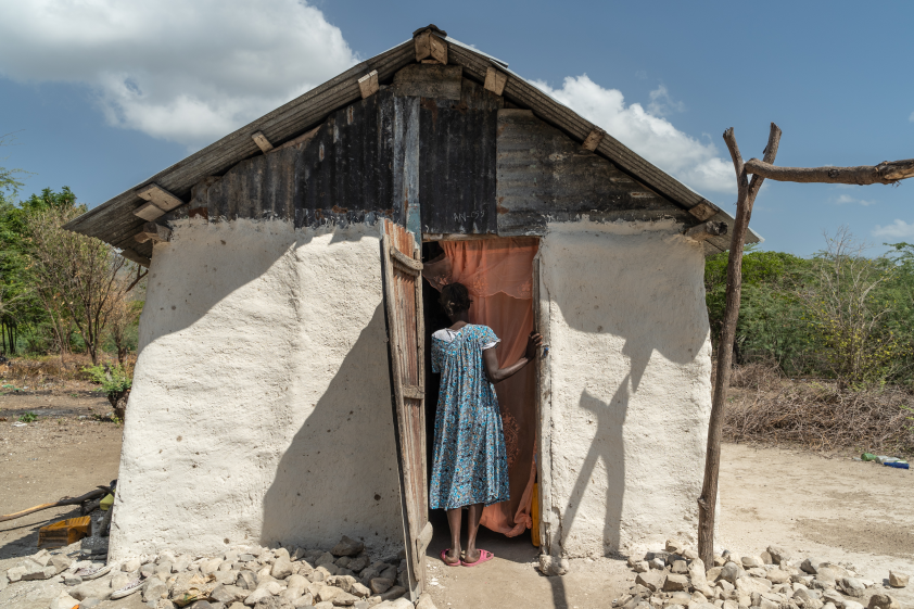 Marie stands outside of her home.