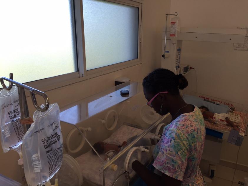 Nurse checking on moise in incubator