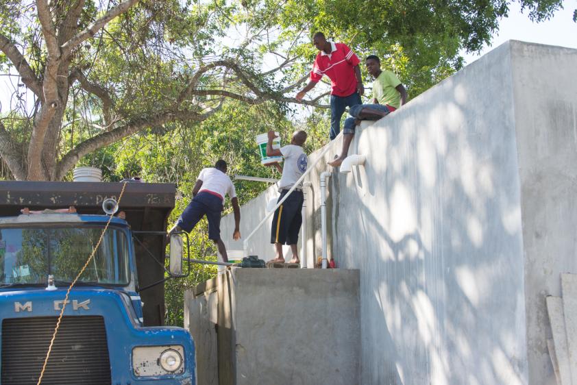 Workers passing buckets of water from the water truck