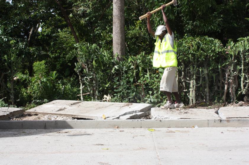 Worker smashing sidewalk cement