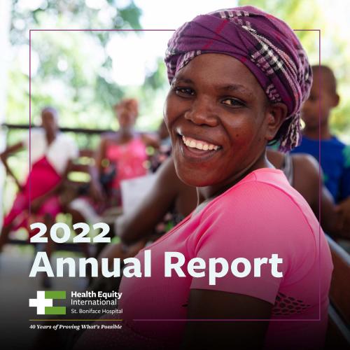 A pregnant Haitian woman is shown from the waist up. She is smiling and turning her head to face the camera. She is wearing a bright pink shirt and purple head wrap. The words "2022 Annual Report" are written in large white font on the bottom of the image.