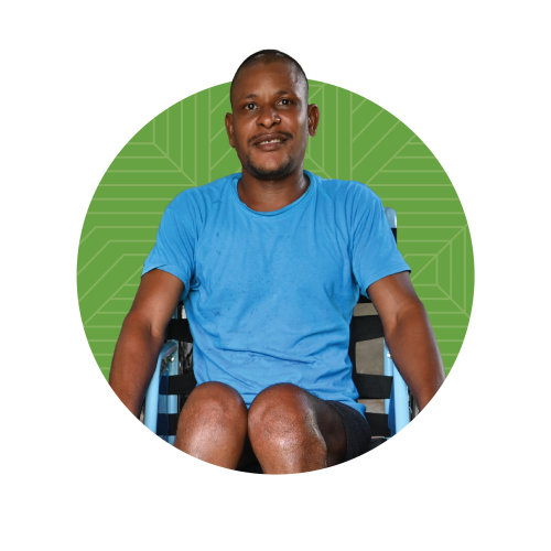 A Haitian man in a wheelchair superimposed over a light green circle with geometric designs on it.