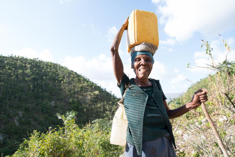 Woman balancing water bucket on head
