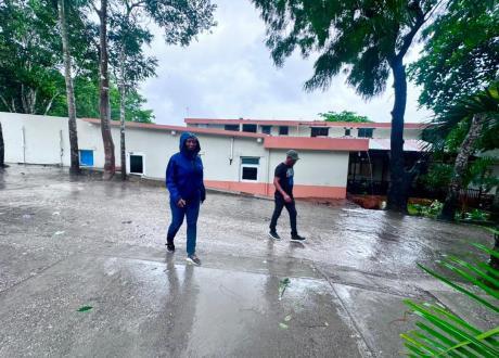 Dr. Miliane Clermont wears a blue rain parka as she walks through St. Boniface Hospital's campus during Hurricane Melissa.