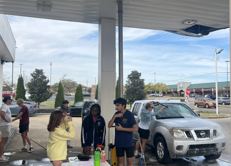 Three students working at a car wash fundraiser