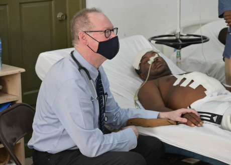 Dr. Farmer sits with a survivor of the August 2021 earthquake in St. Boniface Hospital's surgical recovery room. 