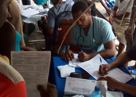 Patients filling out paperwork in mobile clinic