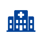 a simple graphic icon of a hospital consisting of one large building with a cross on it and two smaller buildings on either side. The icon is solid dark blue.