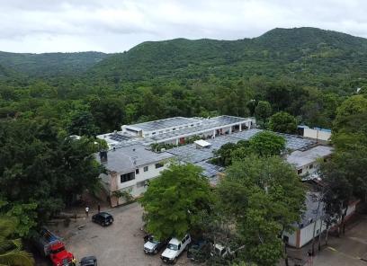 St. Boniface Hospital's campus during Hurricane Melissa. The trees and buildings look wet and the sky is grey and cloudy.