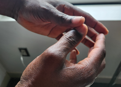 A shelter resident holds his hands together pensively.