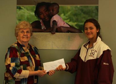 Camille give Nanette, the St. Boniface co founder, a check