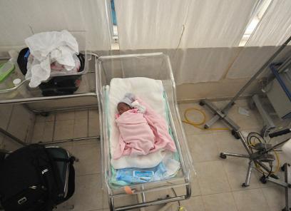 Infant with pink blanket laying in the NICU
