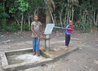 Two young children pumping water