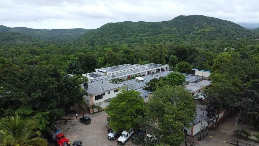St. Boniface Hospital's campus during Hurricane Melissa. The trees and buildings look wet and the sky is grey and cloudy.