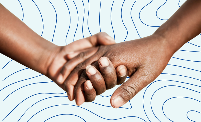 A photo of two dark-skinned hands holding one another on top of a light blue background with thin dark blue topographic lines.