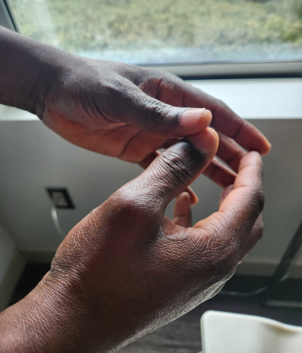 A shelter resident holds his hands together pensively.