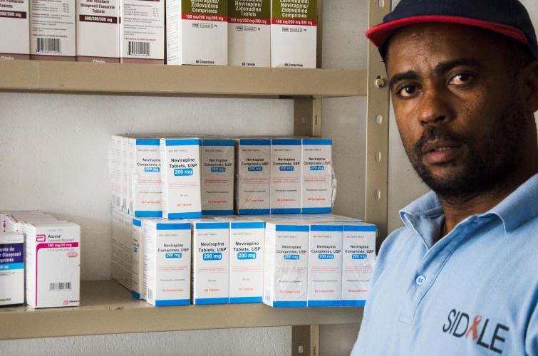 Rene standing in front of a shelf of hiv medications