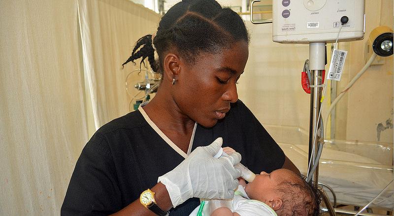 Nurse feeding a newborn with formula