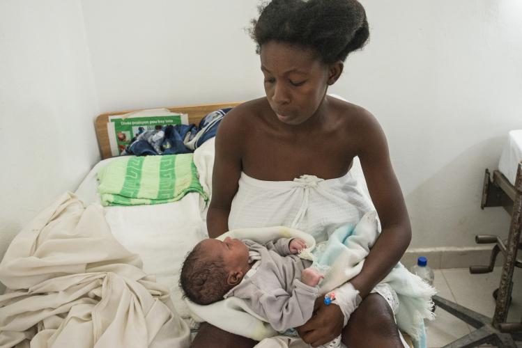 Plesilia holding her newborn baby