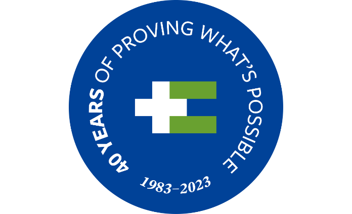 HEI/SBH's 40th anniversary logo—the green and white plus and equal sign logo sits on a dark blue circle surrounded by the text "40 years of proving what's possible 1983-2023"