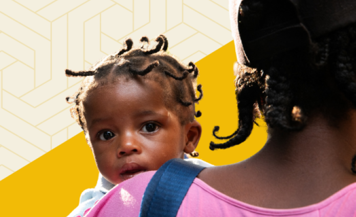 A cutout photo of a baby peeping over her mother’s shoulder. Both are Haitian and have twisted braids.