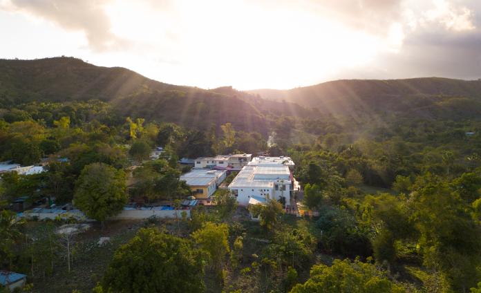 An arial view of St. Boniface Hospital surrounded by lush greenery and mountains