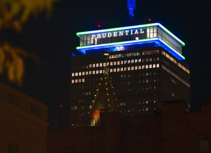 Boston's Prudential Tower lit up in green and blue lights in honor of HEI's 2025 celebration.