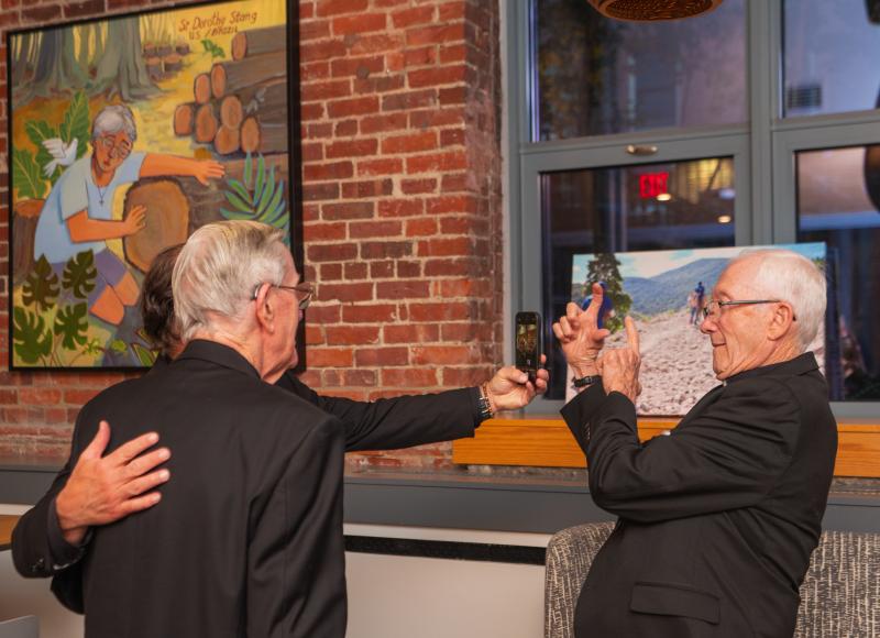 A group of elderly priests pose for photos with one another during an event.