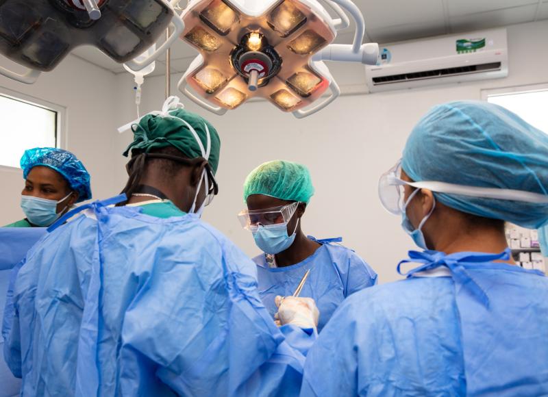 Four Haitian surgeons conduct a surgical procedure. 