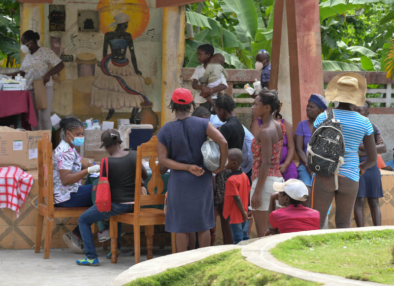 A crowd of patients wait to be seen by a community health nurse at an earthquake mobile clinic.