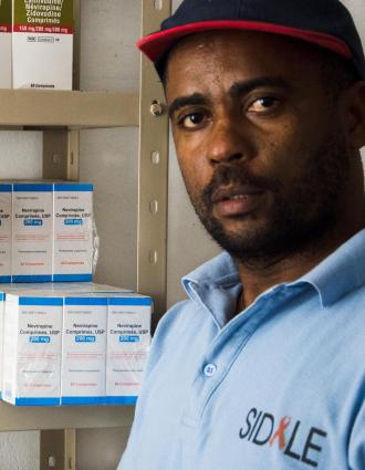 Rene standing in front of a shelf of hiv medications