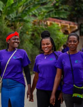 A group of four women Kore Sante team members walk down the street and smile.