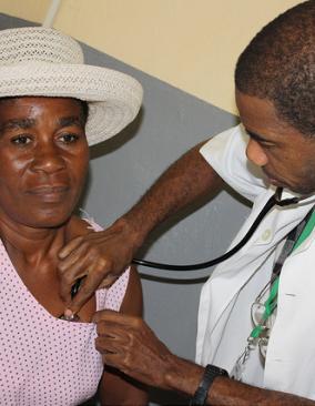 Male doctor in white coat using a stethoscope to listen to a woman's heart.