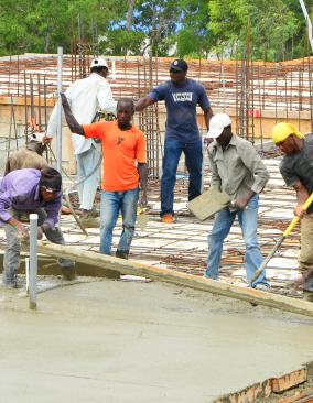 Workers laying the cement for the maternal health center