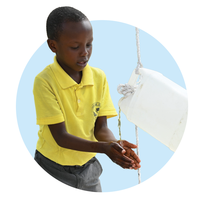 A young Haitian boy washing his hands superimposed on a light blue circle.